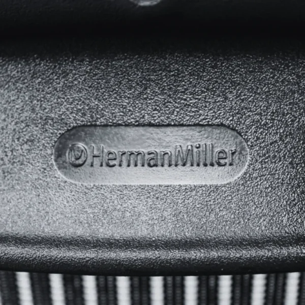 close up view on the brand of refurbished herman miller aeron fixed arms