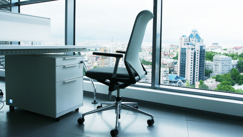 Ergonomic office chair by a large window with a cityscape view - what is an ergonomic chair