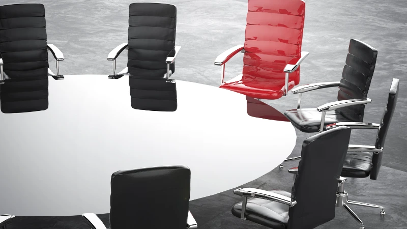 Modern office chairs around a sleek conference table, highlighting a red executive chair as the focal point - why office chairs so expensive.